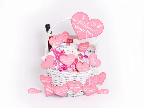 Ein liebevolles geburtstagsgeschenk mama selber machen: Eine weiße Korbtasche gefüllt mit rosa Herzen, die liebevolle Botschaften für Mamas tragen.