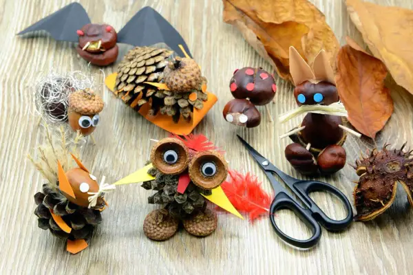 Kreatives Basteln mit Eicheln und Kastanien: Ein Eichhörnchen, ein Vogel und ein Fledermaus-Motiv aus Naturmaterialien.
